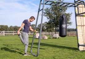 adulte qui s'étire grâce à la barre fixe installée sur la station de musculation Monkeybar