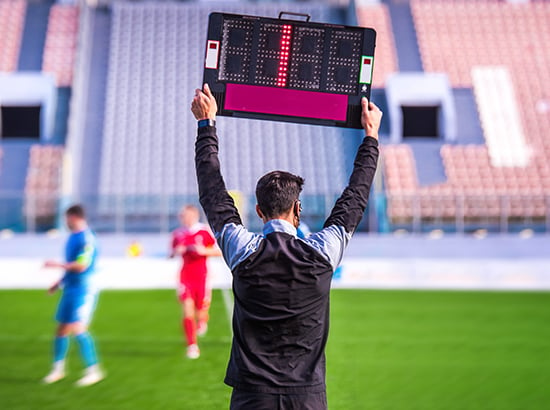 Arbitre assistant qui annonce le temps additionnel