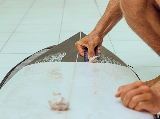 Déwaxage d'une planche de surf.