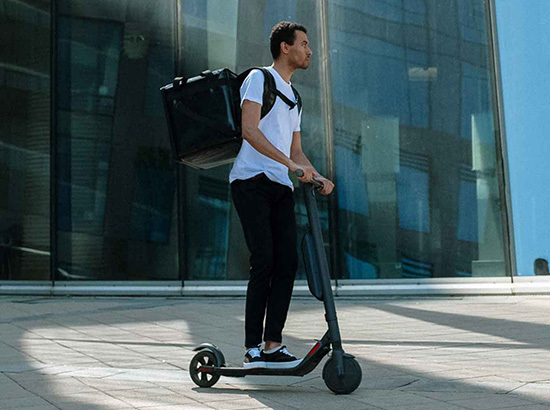 Homme sur une trottinette électrique.