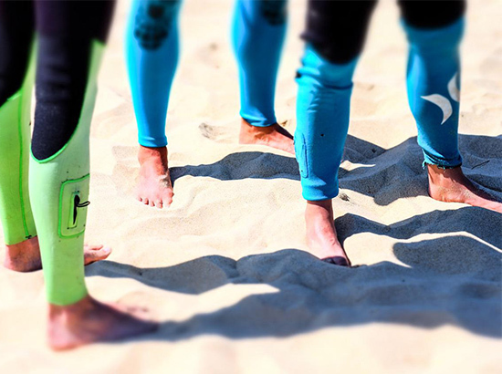 Jambes de surfeurs en combinaison.