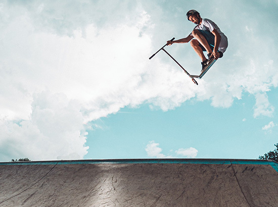 Air en trottinette freestyle dans skate-park